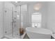 Luxurious main bathroom with walk-in shower, free-standing tub, and custom pendant lighting at 403 Carriage House Ln, Tarpon Springs, FL 34688