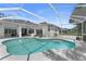 Screened pool with seating, surrounded by outdoor lounging space and beautiful landscaping at 403 Carriage House Ln, Tarpon Springs, FL 34688