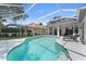 Sparkling pool with screened enclosure, sun loungers, and manicured landscaping in backyard at 403 Carriage House Ln, Tarpon Springs, FL 34688
