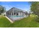 Lush backyard featuring a screened in pool, patio and well manicured lawn at 403 Carriage House Ln, Tarpon Springs, FL 34688