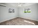Bright and spacious bedroom featuring durable wood-look flooring, ceiling fan and bright windows at 403 Normandy Rd, Madeira Beach, FL 33708