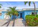 Inviting home featuring a well-maintained front yard, a paver walkway leading to a covered entrance, and lush landscaping at 403 Normandy Rd, Madeira Beach, FL 33708