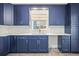 Renovated kitchen features dark blue cabinets, white countertops, and stainless steel appliances at 403 Normandy Rd, Madeira Beach, FL 33708