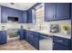 Updated kitchen featuring navy blue cabinets, stainless steel appliances, quartz countertops, and a decorative backsplash at 403 Normandy Rd, Madeira Beach, FL 33708