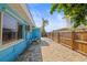 Side yard of waterfront home showing brick-paved area with pool equipment and partial fencing at 403 Normandy Rd, Madeira Beach, FL 33708