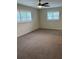 Bright bedroom with neutral carpet, two windows and a ceiling fan at 5281 Venetian Ne Blvd, St Petersburg, FL 33703