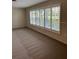 Bright living room featuring neutral carpet and large windows with plantation shutters at 5281 Venetian Ne Blvd, St Petersburg, FL 33703