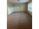 Spacious living room featuring neutral carpet and a window with plantation shutters at 5281 Venetian Ne Blvd, St Petersburg, FL 33703