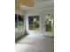 Enclosed patio with tile flooring and fan overlooking the lush landscaping at 5281 Venetian Ne Blvd, St Petersburg, FL 33703