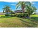 Expansive backyard featuring lush landscaping, mature palm trees, and a screened-in patio area at 5457 Sandy Shell Dr, Apollo Beach, FL 33572
