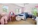 Bright bedroom with pink walls, white bed frame, and two windows letting in natural light at 5457 Sandy Shell Dr, Apollo Beach, FL 33572