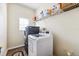 Bright laundry room with modern washer and dryer, along with shelves for storage at 5457 Sandy Shell Dr, Apollo Beach, FL 33572