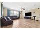 Large living room with wood flooring, a leather sofa and a large flat screen TV at 5457 Sandy Shell Dr, Apollo Beach, FL 33572
