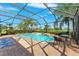 Screened-in pool with a view of the lake and palm trees providing a relaxing outdoor space at 5457 Sandy Shell Dr, Apollo Beach, FL 33572