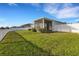 Expansive backyard with a well-maintained lawn, screened lanai, and white fence, creating a serene outdoor space at 6211 114Th E Dr, Parrish, FL 34219