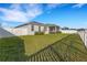 Spacious backyard featuring a green lawn, screened lanai, and secure white fence, perfect for outdoor activities at 6211 114Th E Dr, Parrish, FL 34219
