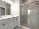 A modern bathroom featuring a double vanity with a quartz countertop and a glass-enclosed shower at 6211 114Th E Dr, Parrish, FL 34219