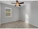 A bright bedroom with a ceiling fan, window with blinds, and stylish, light-colored herringbone floors at 6211 114Th E Dr, Parrish, FL 34219