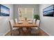 Dining area features a wooden table with seating for four, decorated with nature-themed wall art at 6211 114Th E Dr, Parrish, FL 34219