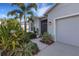 Close-up of the front entrance showcasing the well-maintained landscaping, neutral exterior, and a screened entryway at 6211 114Th E Dr, Parrish, FL 34219