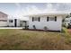 Side view showcasing the home's white brick exterior, dark shutters, and inviting curb appeal at 6304 Memorial Hwy, Tampa, FL 33615