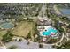 Aerial view of community with lake, clubhouse, pool, basketball court, green space, and parking at 6512 Trent Creek Dr, Sun City Center, FL 33573