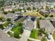 Aerial view of a well-manicured home with solar panels, a fenced backyard, and a two-car garage at 6512 Trent Creek Dr, Sun City Center, FL 33573