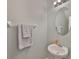 Clean half-bathroom with a pedestal sink, oval mirror and fresh gray towels at 6512 Trent Creek Dr, Sun City Center, FL 33573