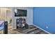 Bedroom featuring plank flooring, blue accent wall, entertainment center with wall-mounted TV, and white closet door at 6512 Trent Creek Dr, Sun City Center, FL 33573