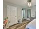 A bright bedroom with wood floors, a white door, and a decorative mirror at 6512 Trent Creek Dr, Sun City Center, FL 33573