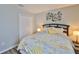 Bedroom featuring yellow floral bedding, dark wood floors, and modern wall decor at 6512 Trent Creek Dr, Sun City Center, FL 33573