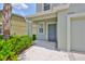 Inviting front entrance with a gray door, covered porch, and lush landscaping at 6512 Trent Creek Dr, Sun City Center, FL 33573