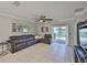 Bright living room boasts tile floors, modern ceiling fan, and sliding glass doors to the backyard at 6512 Trent Creek Dr, Sun City Center, FL 33573