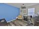 Home office features a blue accent wall, wood floors, and a modern ceiling fan at 6512 Trent Creek Dr, Sun City Center, FL 33573