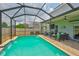Backyard screened pool with outdoor lounge seating and covered patio with ceiling fans at 6512 Trent Creek Dr, Sun City Center, FL 33573