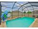 Backyard screened pool with waterfall feature, basketball hoop, and views of the surrounding fenced yard at 6512 Trent Creek Dr, Sun City Center, FL 33573