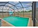 Backyard screened pool with waterfall feature, basketball hoop, and hardscape border at 6512 Trent Creek Dr, Sun City Center, FL 33573