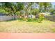 Large, grassy backyard featuring mature trees, wooden privacy fence, and a storage shed at 7065 73Rd N St, Pinellas Park, FL 33781