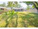 Large backyard with lush lawn, privacy fence, mature landscaping, and backyard patio at 7065 73Rd N St, Pinellas Park, FL 33781