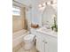 Bright bathroom featuring a shower-tub combo, neutral tile, and a white vanity with modern fixtures at 7313 Royal Palm Dr, New Port Richey, FL 34652