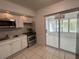Bright kitchen featuring stainless steel appliances, tile floors and a connecting sun room at 7313 Royal Palm Dr, New Port Richey, FL 34652
