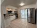 Well-lit kitchen featuring stainless steel appliances, sliding glass doors and ample natural light at 7313 Royal Palm Dr, New Port Richey, FL 34652