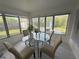 Inviting sun room with a glass table, four chairs, and large windows for ample natural light at 7313 Royal Palm Dr, New Port Richey, FL 34652