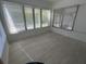 Bright sun room featuring large windows and neutral tile floors at 7313 Royal Palm Dr, New Port Richey, FL 34652
