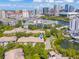 Expansive aerial shot of condos surrounded by mature trees, overlooking a scenic waterway and city buildings at 741 Mainsail Dr, Tampa, FL 33602