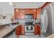 Modern kitchen featuring sleek stainless steel appliances, warm wood cabinets, and stylish backsplash tiles at 741 Mainsail Dr, Tampa, FL 33602