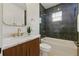 Modern bathroom features a bathtub with dark tiled walls and a wood vanity at 791 44Th N Ave, St Petersburg, FL 33703