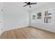 A bright bedroom featuring a ceiling fan, wood-look flooring, and multiple windows at 791 44Th N Ave, St Petersburg, FL 33703