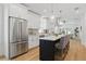 A chef's kitchen with stainless appliances, white cabinetry, island and pendant lighting at 791 44Th N Ave, St Petersburg, FL 33703