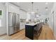 A chef's kitchen with stainless appliances, white cabinetry, island and pendant lighting at 791 44Th N Ave, St Petersburg, FL 33703